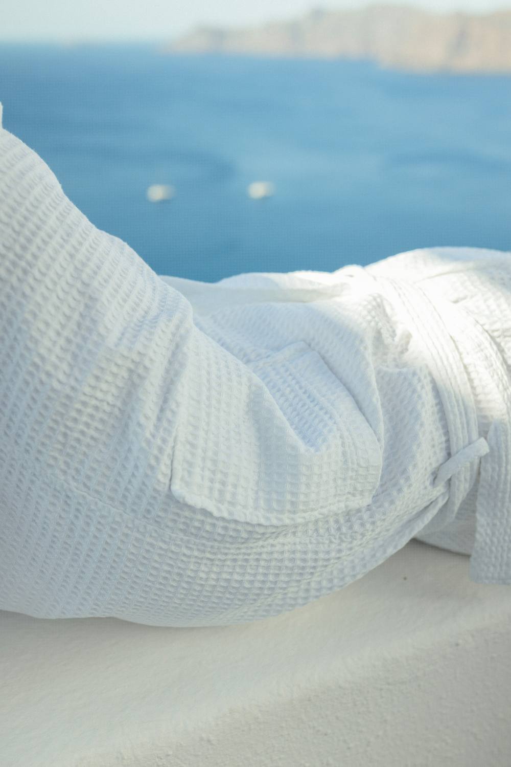 Albornoz blanco de nido de abeja junto al mar