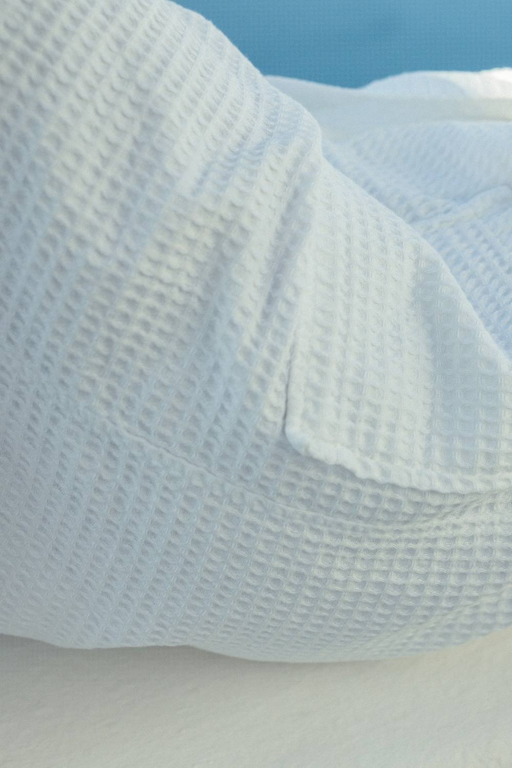 Detalle de la manga de un albornoz blanco de nido de abeja