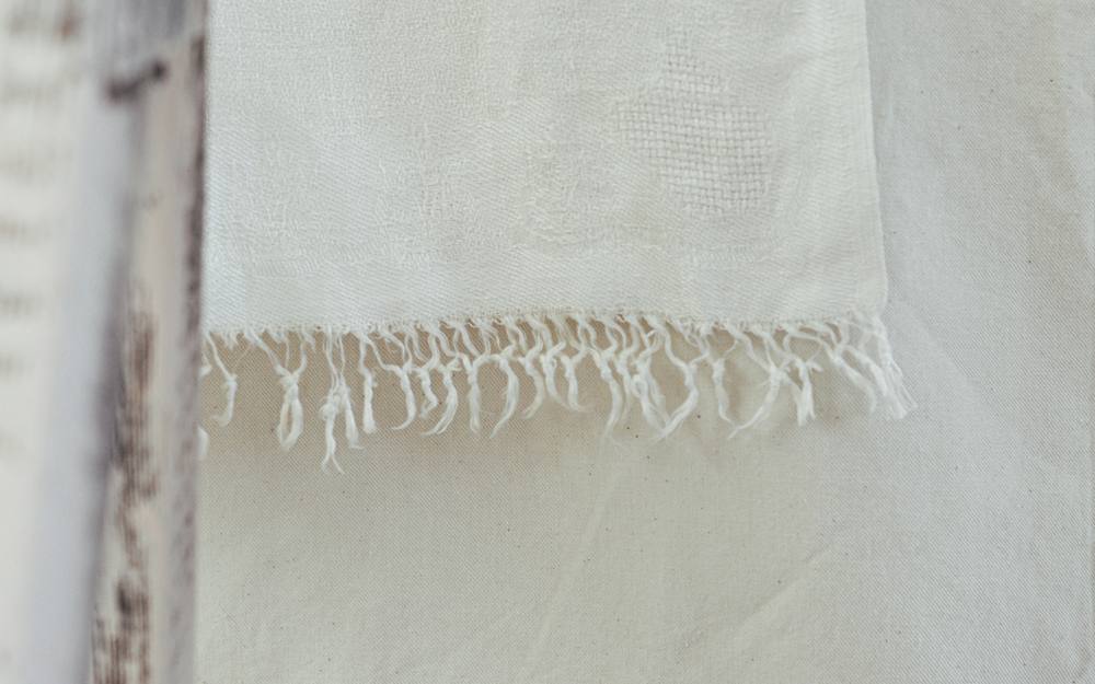 Primer plano de un tejido de algodón blanco con flecos