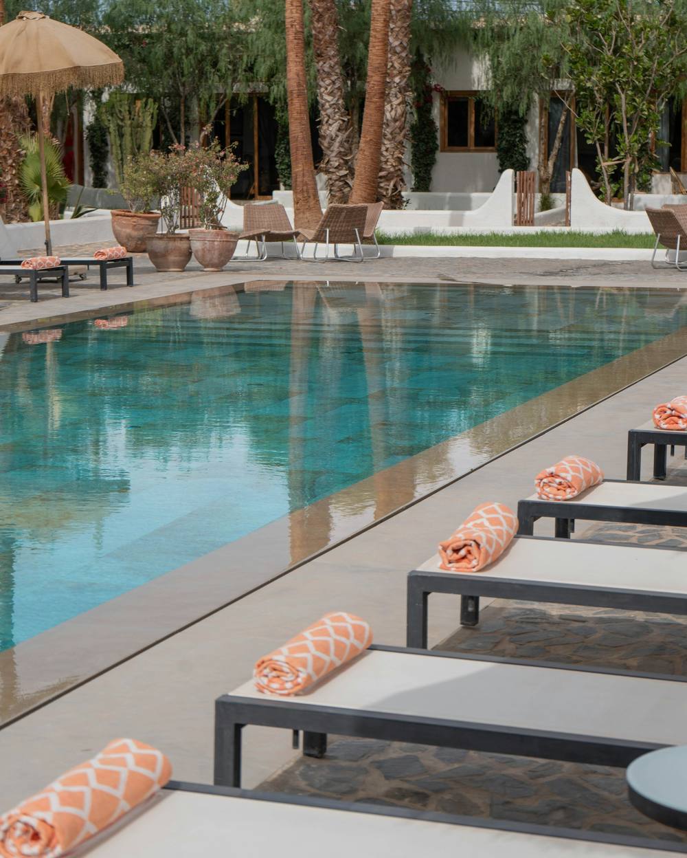 Piscina con tumbonas y toallas en tonos terracota