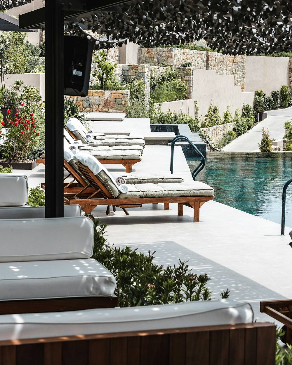 Piscina de un resort con tumbonas acolchadas