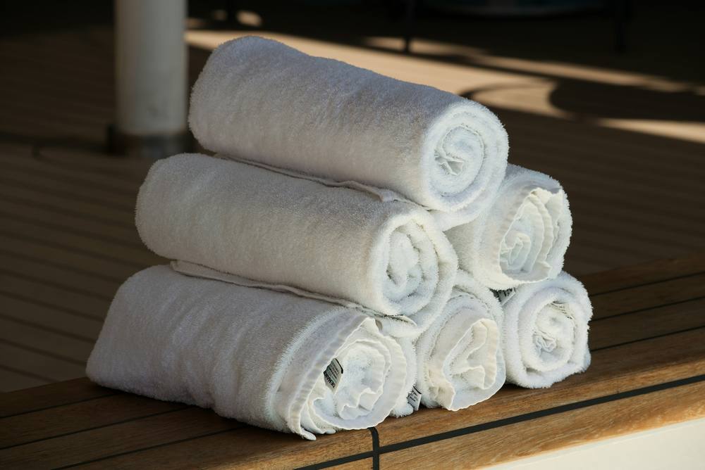 Toallas blancas enrolladas sobre una tarima de madera